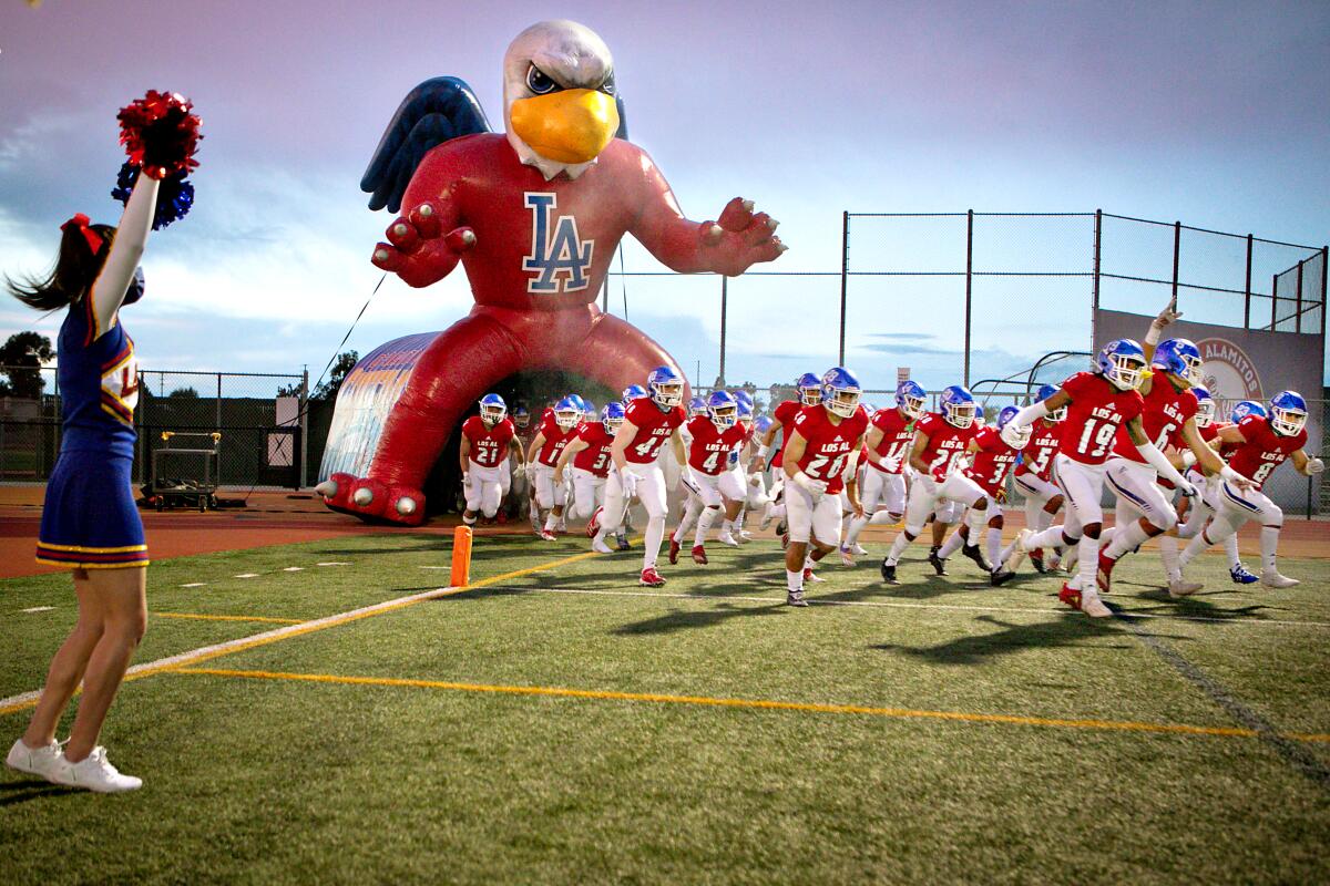 The Los Alamitos football team enters the field for its first game of the season against Millikan in 2021.