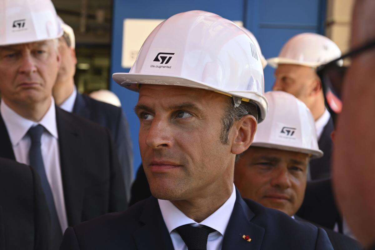 French President Emmanuel Macron listens to explanations as he visits the STMicroelectronics (STM) company in Crolles, southeastern France, Tuesday July 12, 2022. Emmanuel Macron announced on July 11, 2022 5.7 billion euros investment by Franco-Italian STMicroelectronics and American GlobalFoundries to build a semiconductor plant in Crolles, near Grenoble. (Jean-Philippe Ksiazek, pool via AP)