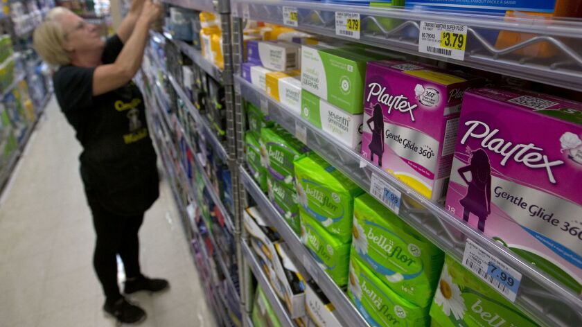 A woman restocks tampons at a Sacramento market in 2016.