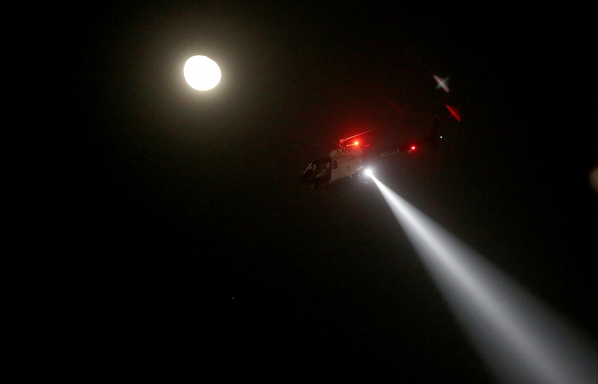 A police helicopters hovers over downtown Los Angeles, where protesters gathered on Tuesday night