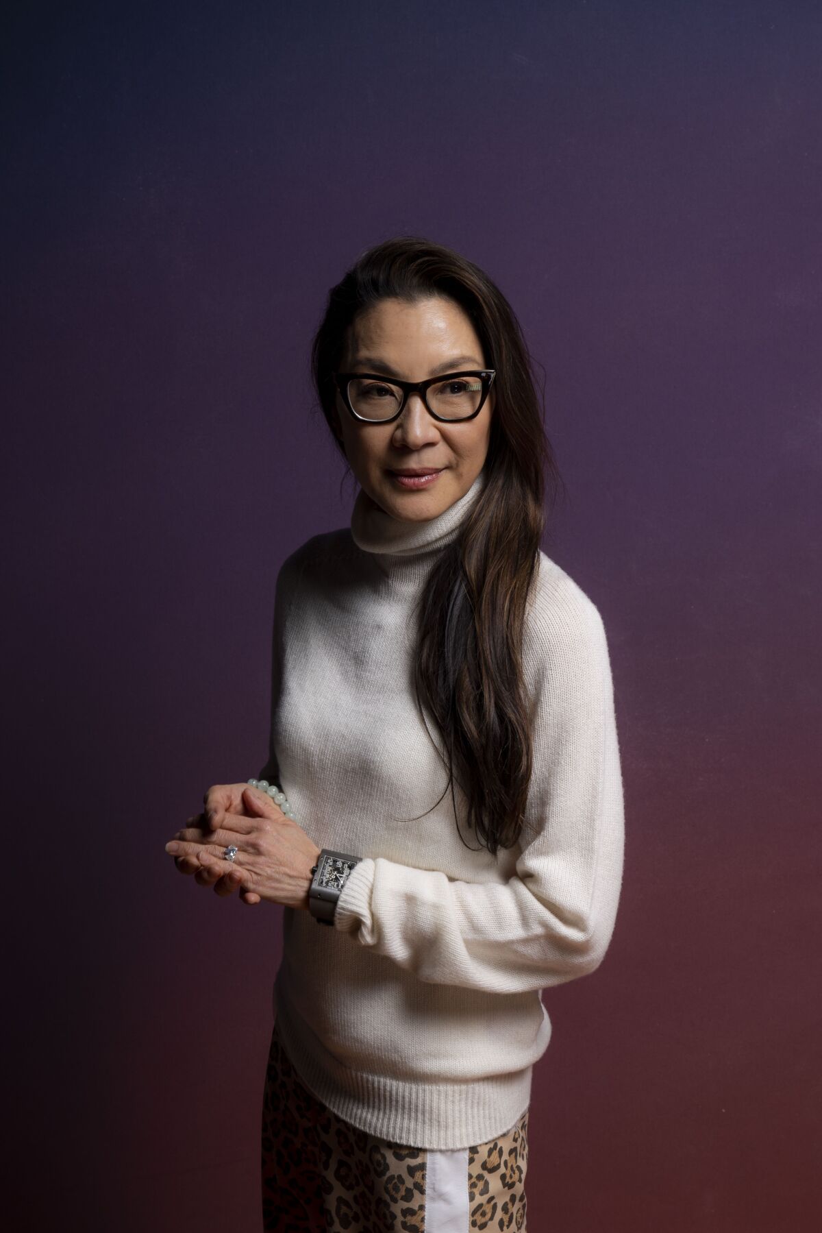 Woman with long dark hair wearing a white turtleneck sweater