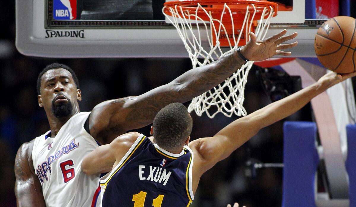Clippers center DeAndre Jordan tries to block a shot by Utah Jazz guard Dante Exum during a preseason game.