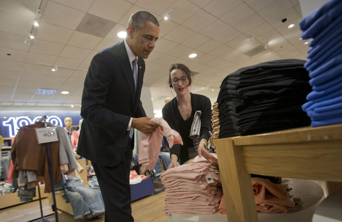 President Obama, with the help of store employee Susan Panariello, shops for sweaters at a Gap store in Manhattan.