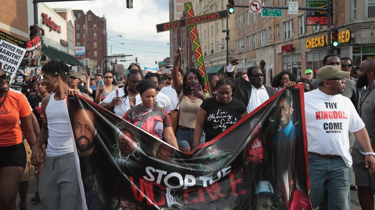 Demonstrators march through the South Shore neighborhood on Sunday protesting the shooting death of 37-year-old Harith Augustus in Chicago.