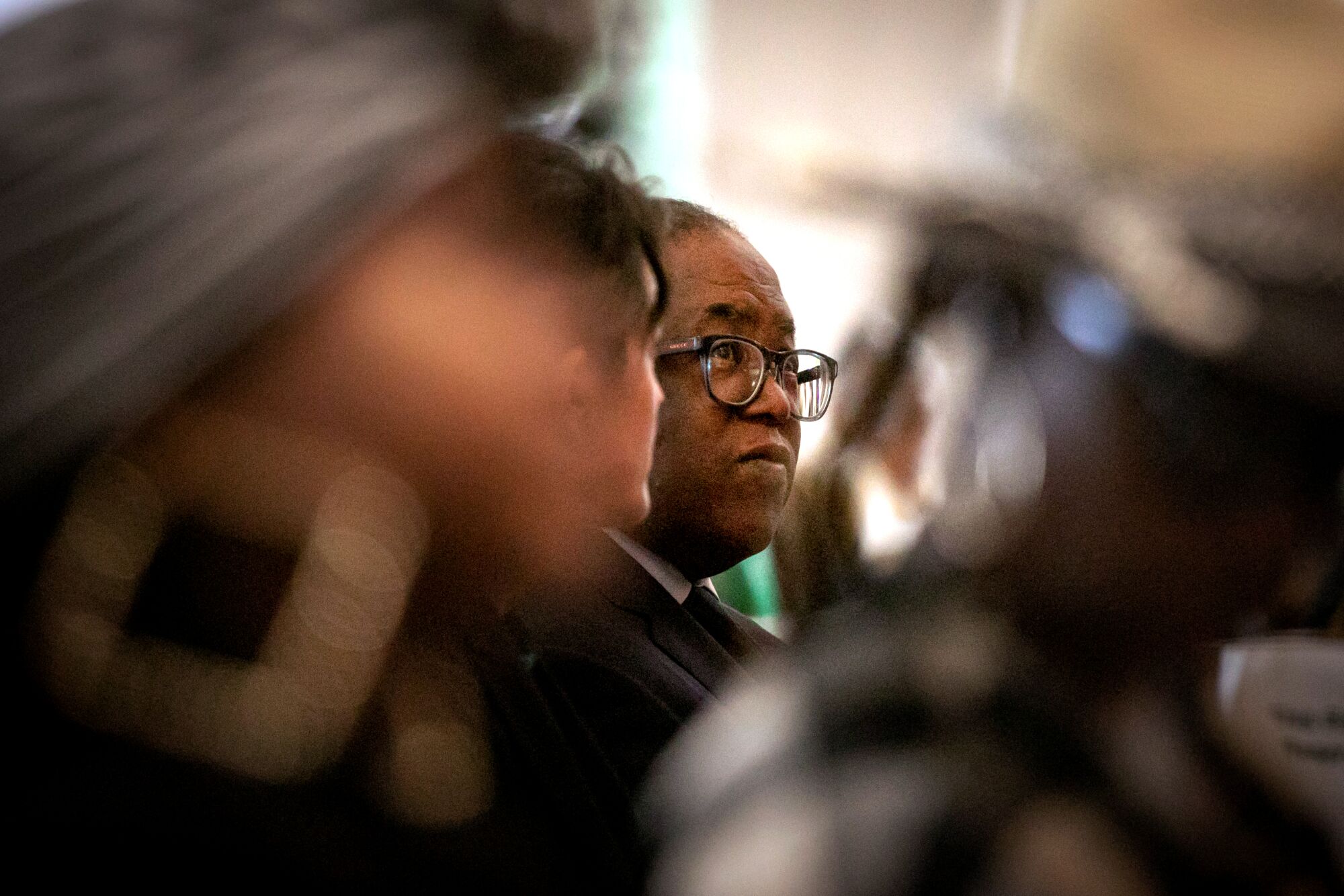 man in glasses is seen in focus through a crowd 