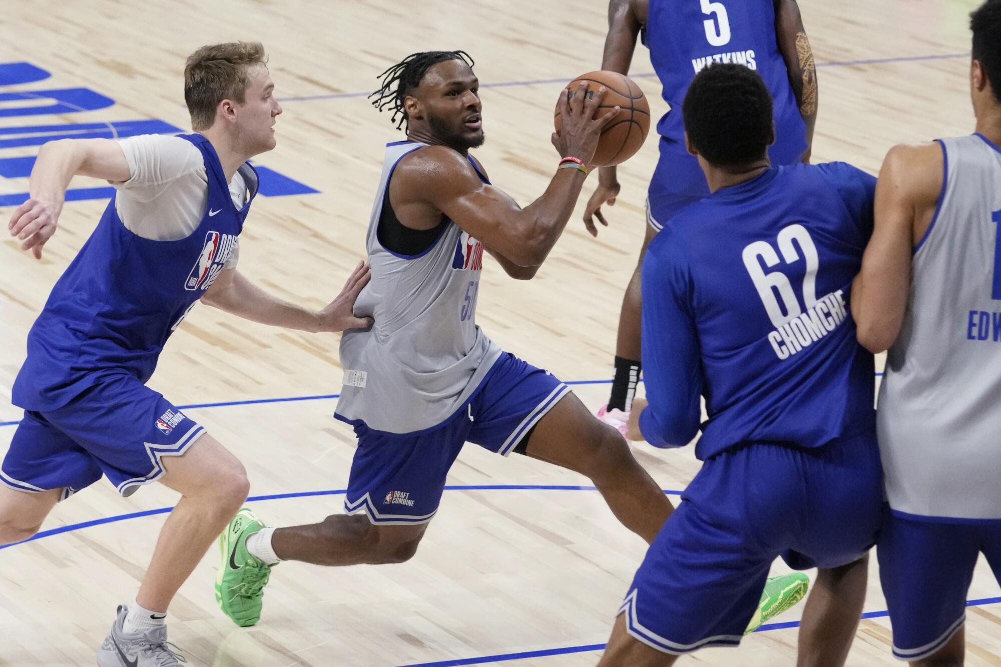 Bronny James (ortada), Salı günü Chicago'daki NBA draftında soldaki Cam Spencer'ın yanından potaya doğru ilerliyor.