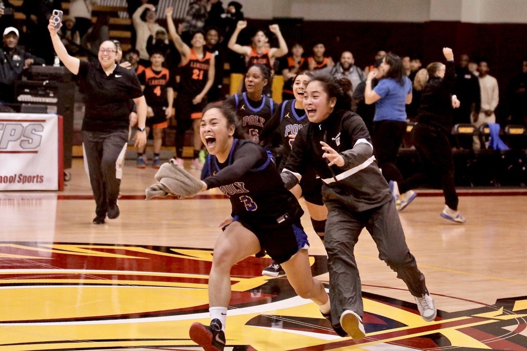 Hannah and Heart Lising sprint off the bench to celebrate with their teammates after Poly’s victory Saturday.