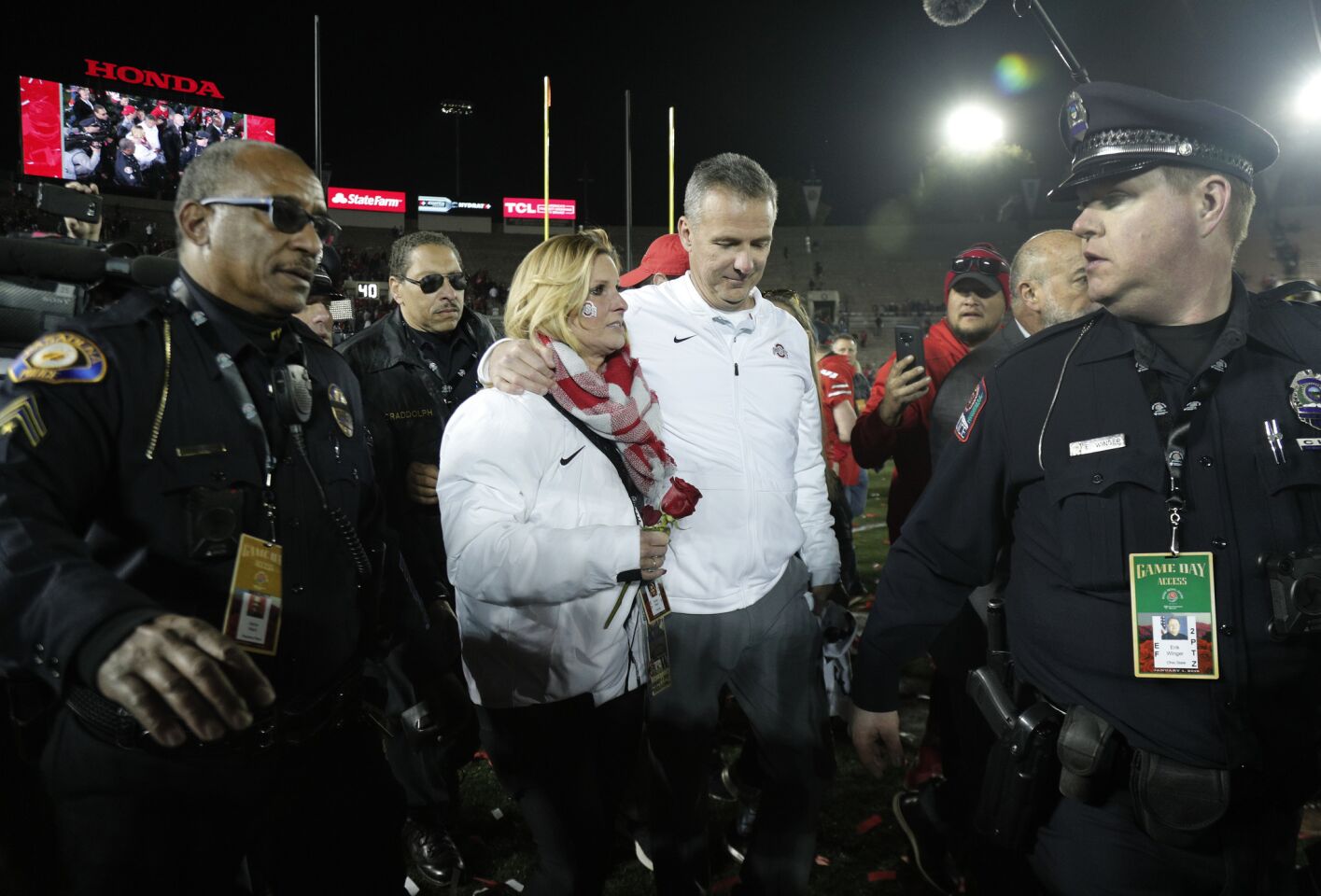 Ohio State Buckeyes coach Urban Meyer with his wife Shelley leave the field with a police escort after beating Washington 28-23 at the Rose Bowl on Jan. 1.