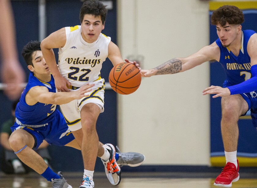 Marina's Robert Aguirre splits Fountain Valley's JJ Gray, left, and Fernando Garcia during a Wave League game.