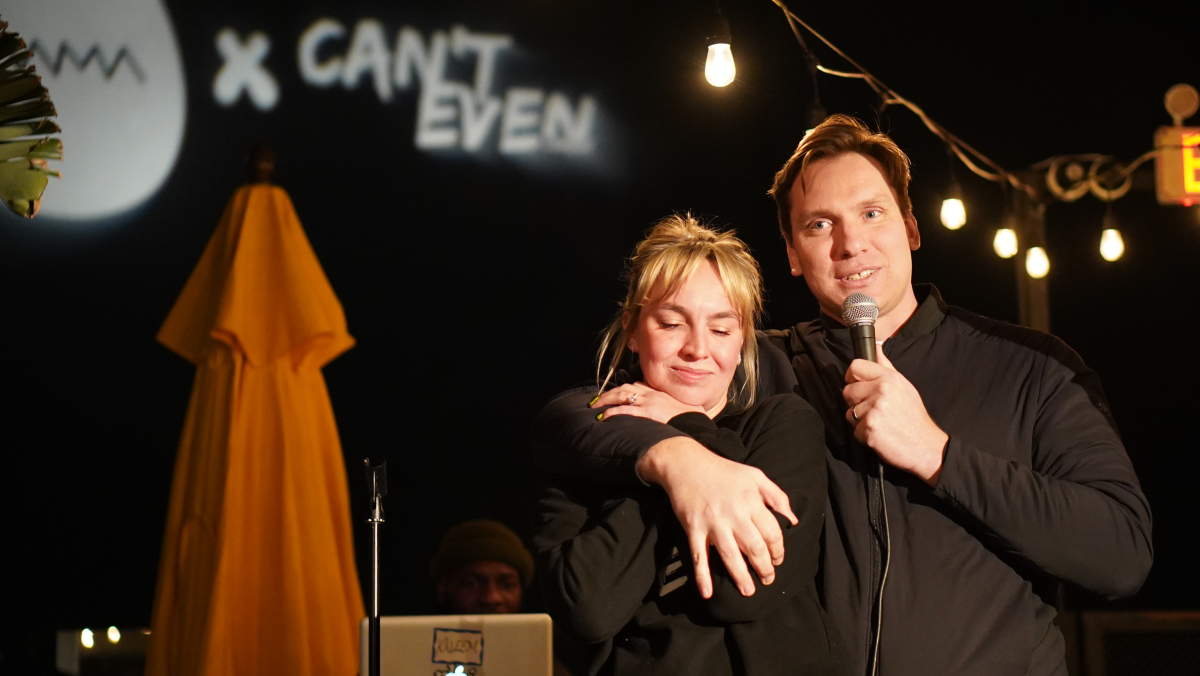 Caitlin and Maxwell Benson smile onstage.