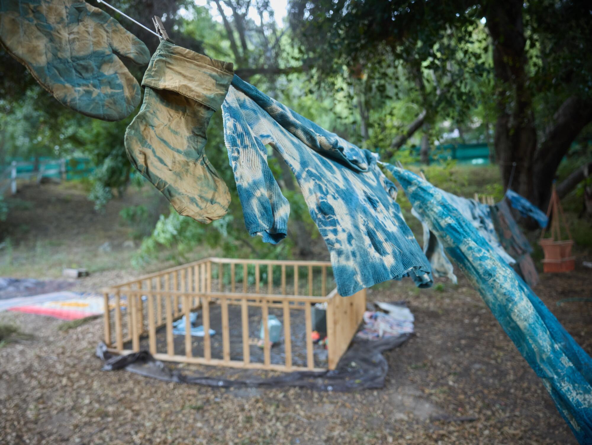 A tie-dye sheet hangs over a play pen. 