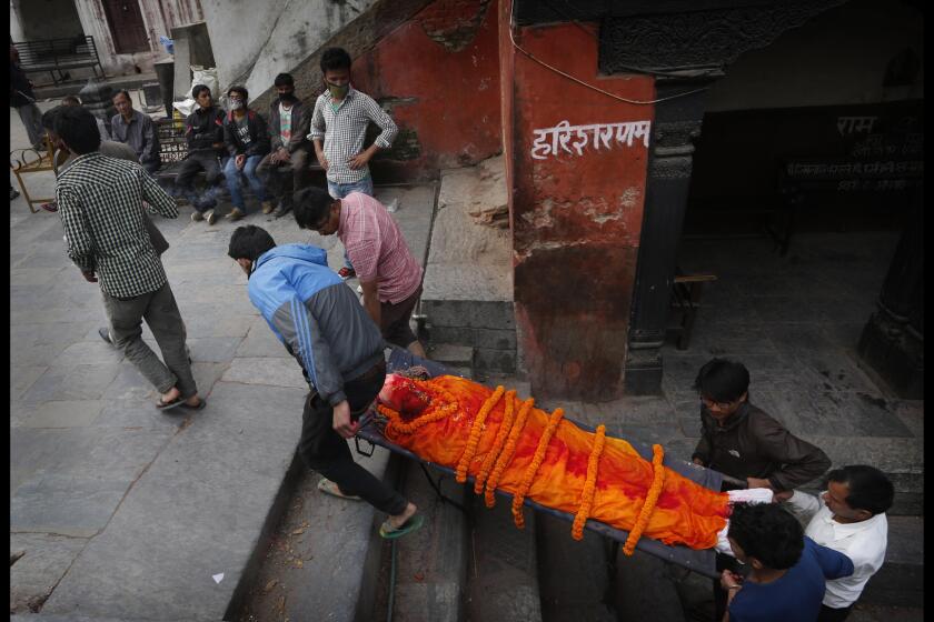 Nepalese carry the body of a relative killed in the massive earthquake to the Pashupatinath temple, on the banks of Bagmati River, for cremation.