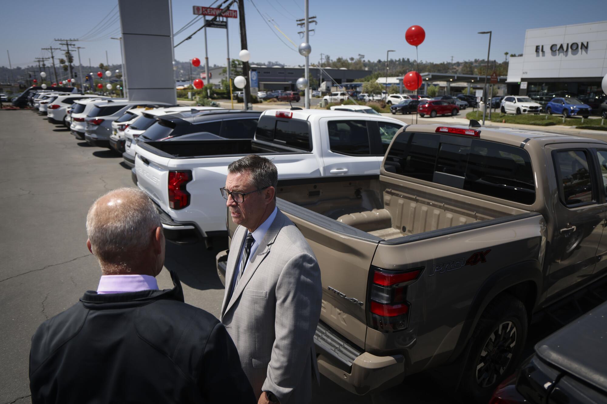 Attorney Michael Roger speaks with Chris George, the general manager of Team Kia of El Cajon.