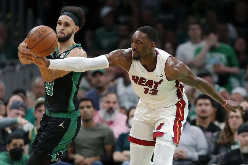 Miami Heat's Bam Adebayo (13) tries to strip the ball from Boston Celtics' Derrick White.