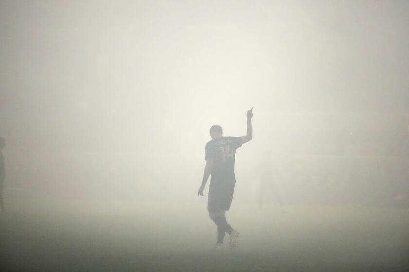 LAFC defender Giorgio Chiellini gestures amid smoke that delayed play during the first half of a playoff match