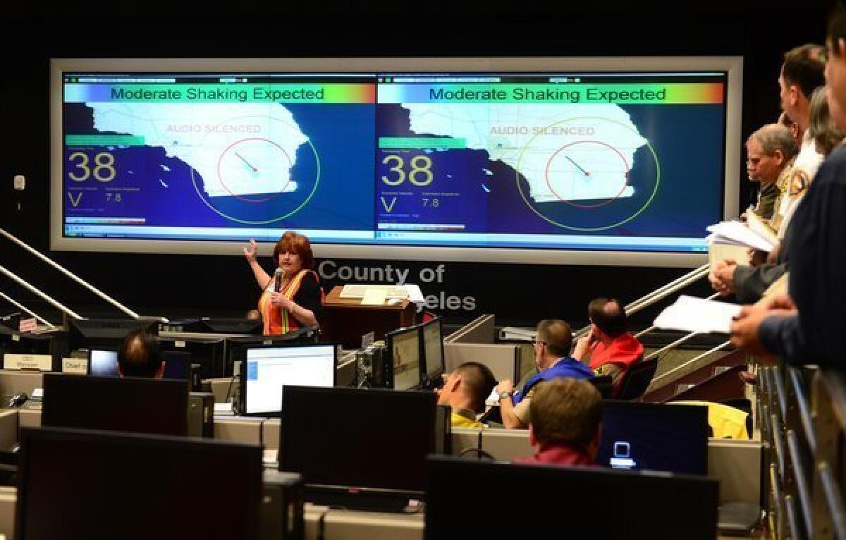 Margaret Vinci from Caltech briefs participants ahead of a functional exercise for first responders in a simulated 7.8 magnitude earthquake drill at the Office of Emergency Management in Los Angeles. This year's exercise featured the California Integrated Seismic Network's Earthquake Early Warning Demonstration System, as seen on screens pictured here.
