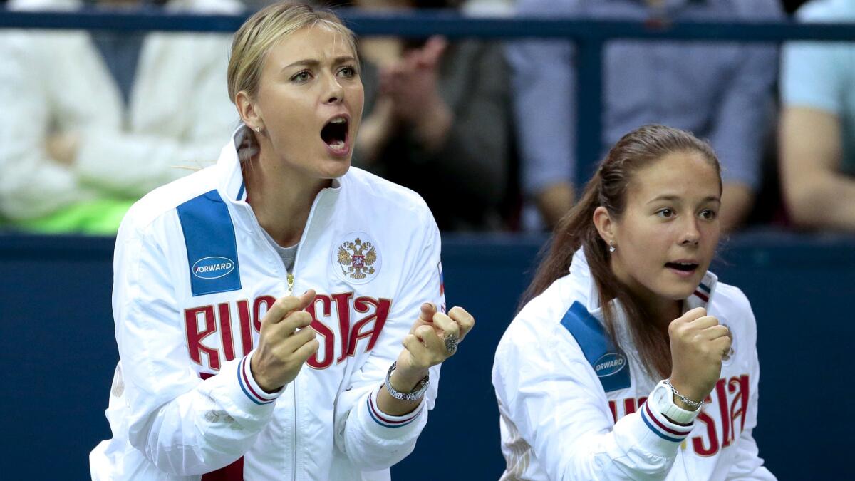 Maria Sharapova, left, and Darya Kasatkina root for Russian teammate Svetlana Kuznetsova during a Fed Cup match against the Netherlands on Feb. 6.