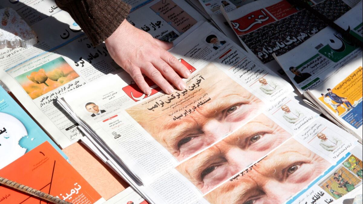 A man adjusts copies of the Iranian daily newspaper 'Shargh' with a picture of President Trump on its front page at his kiosk in Tehran, Iran on April 9.