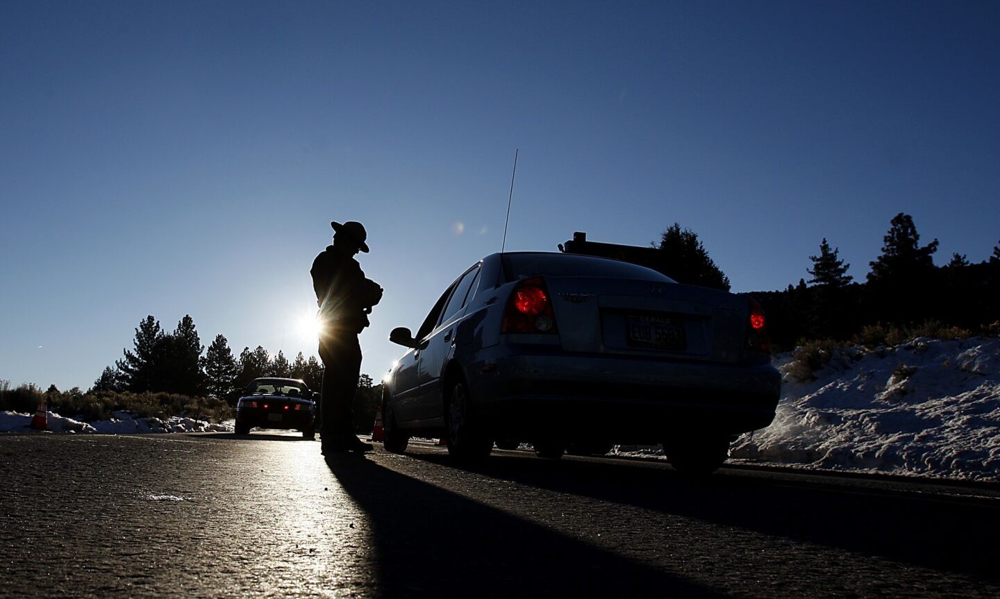 A California Highway Patrolman stops motorists from driving further down Highway 38 near Big Bear on Wednesday morning.