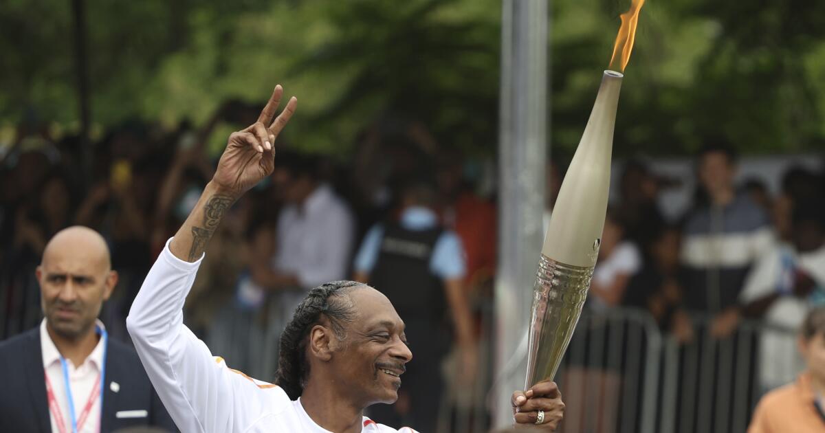 Snoop Dogg carries the Olympic torch very near Paris