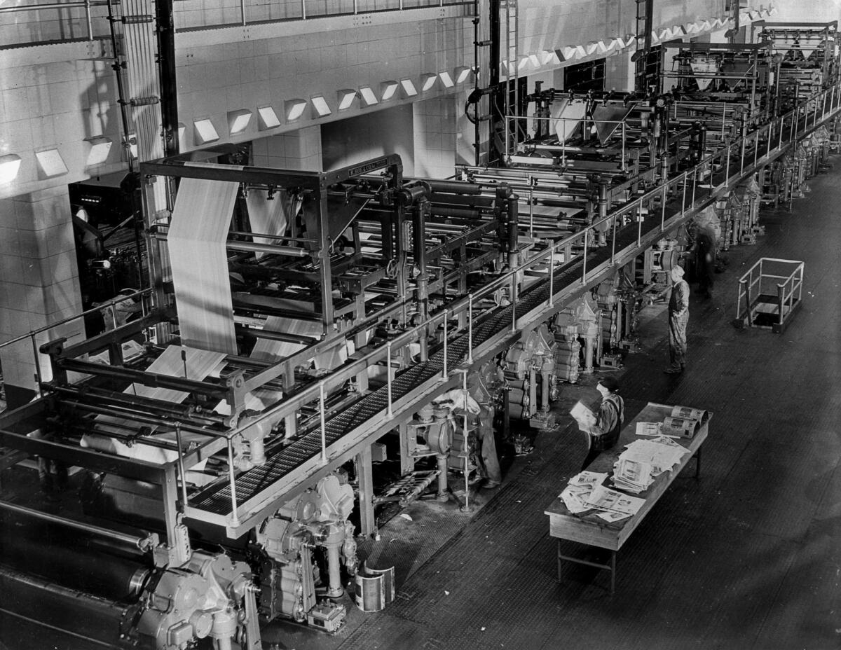 The Los Angeles Times printing presses in 1937, as seen from the mezzanine level. The four eight-unit Hoe presses are new. The older presses are in a room partially visible to the left.