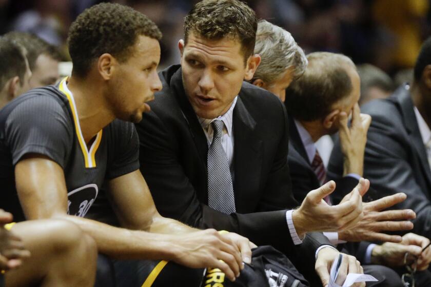 Warriors interim coach Luke Walton talks with guard Stephen Curry during the first half of a game on Oct. 17.