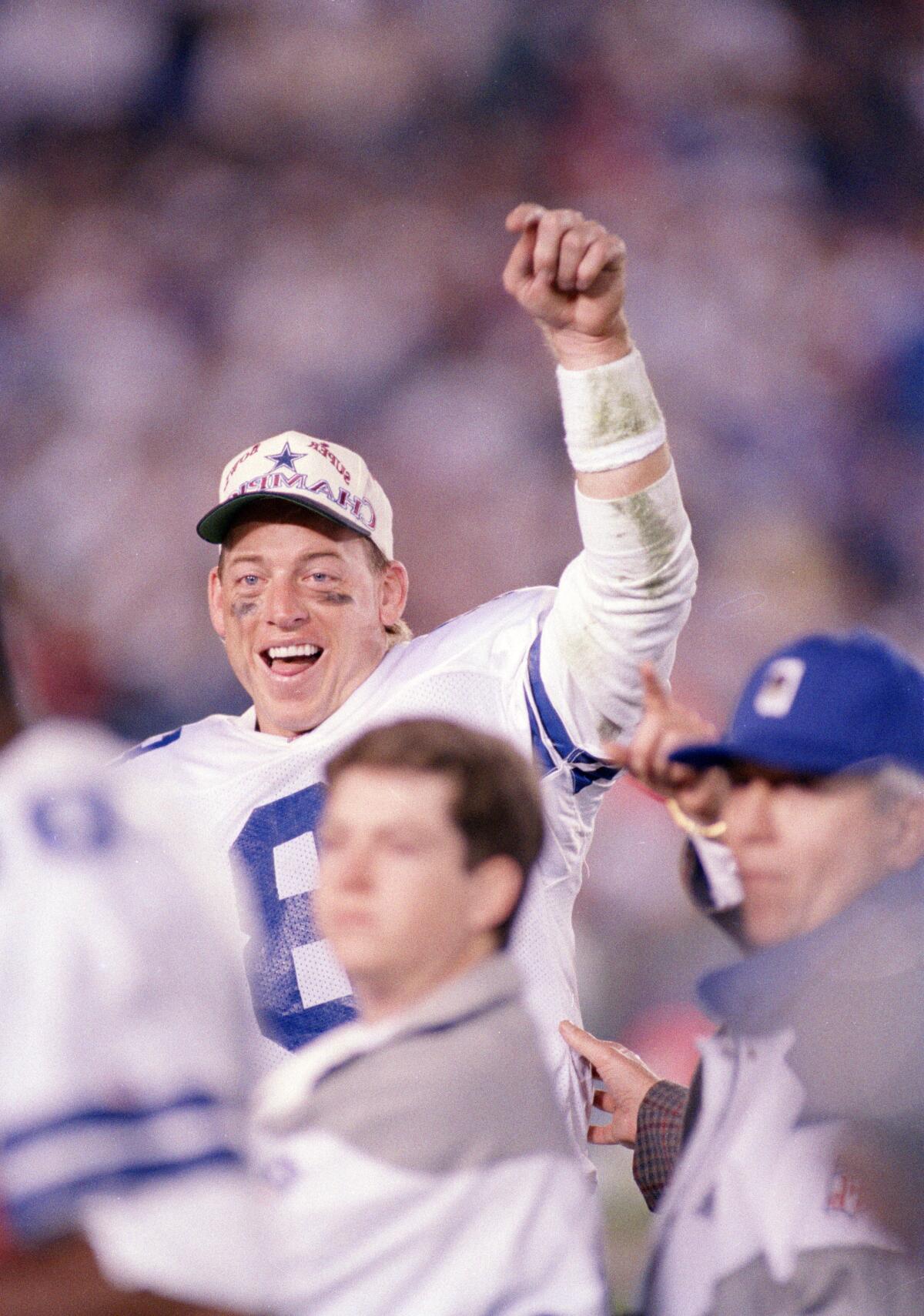 Dallas Cowboys quarterback Troy Aikman smiles and lifts a fist while celebrating at Super Bowl XXVII.