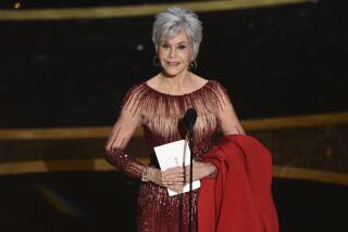 Jane Fonda holding an Oscars envelope on stage