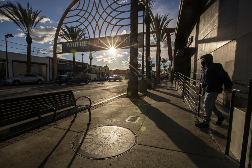 EAST LOS ANGELES, CA - March 11: A pedestrian walks by the sundial plaque honoring Cesar Chavez, who was a Latino American civil rights activist, labor leader, community organizer and businessman, at the Latino Walk of Fame on Whittier Blvd. in East Los Angeles Thursday, March 11, 2021. Chavez' sundial plaque was the first on the Walk of Fame, a collection of 10 sundial plaques on Whittier Boulevard that have fallen into disrepair. Eventually, more than 200 plaques will line the boulevard that cuts through East Los Angeles, an unincorporated area of the Eastside. It was inaugurated on April 30, 1997 by the Whittier Blvd. Merchant Assoc of East Los Angeles. (Allen J. Schaben / Los Angeles Times)