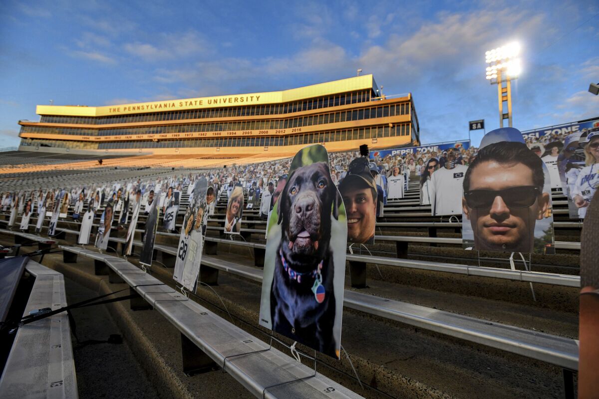 FILE - In this Oct. 31, 2020, file photo, cardboard cutouts of fans sit in the south stands before an NCAA college football game between Penn State and Ohio State in State College, Pa. In 2021, college football will attempt to return to normal after a season roiled by the pandemic while also adapting to a new paradigm in which the athletes have more power than ever before. (AP Photo/Barry Reeger, File)