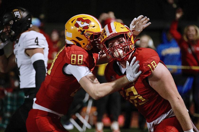 Mission Viejo's Jack Matranga (right) gets a hug from teammate Grant Nichols after his touchdown catch on a fake field goal.