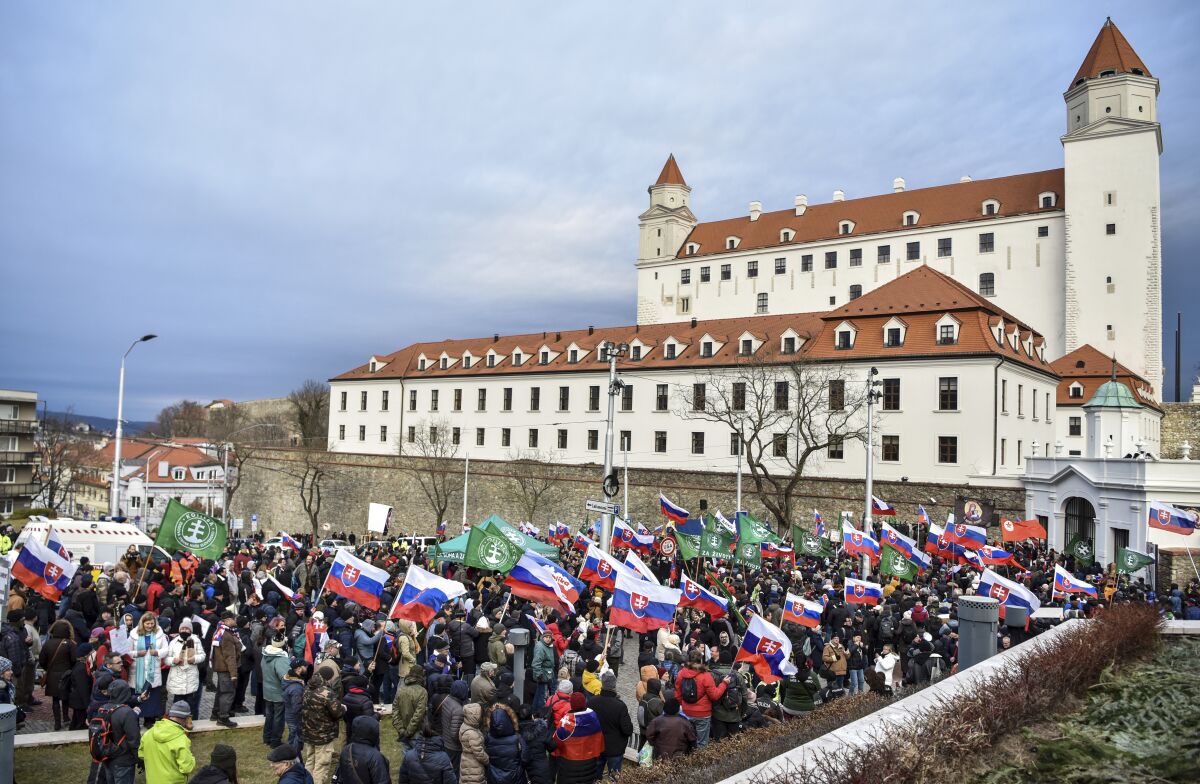 Thousands of Slovaks rally to protest a defense military treaty between this NATO member and the United States, in Bratislava, Slovakia, Tuesday, Feb. 8, 2022. Waving national flags, the protesters gathered in front of the Parliament that was debating the Defense Cooperation Agreement. (Pavol Zachar/TASR via AP)