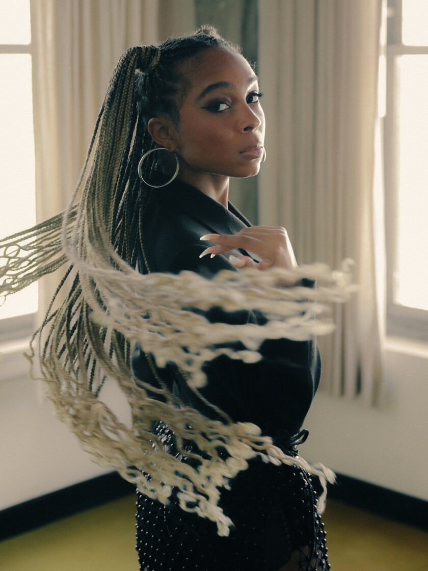 Eva Reign, with long dreadlocks and a shawl, swirls around