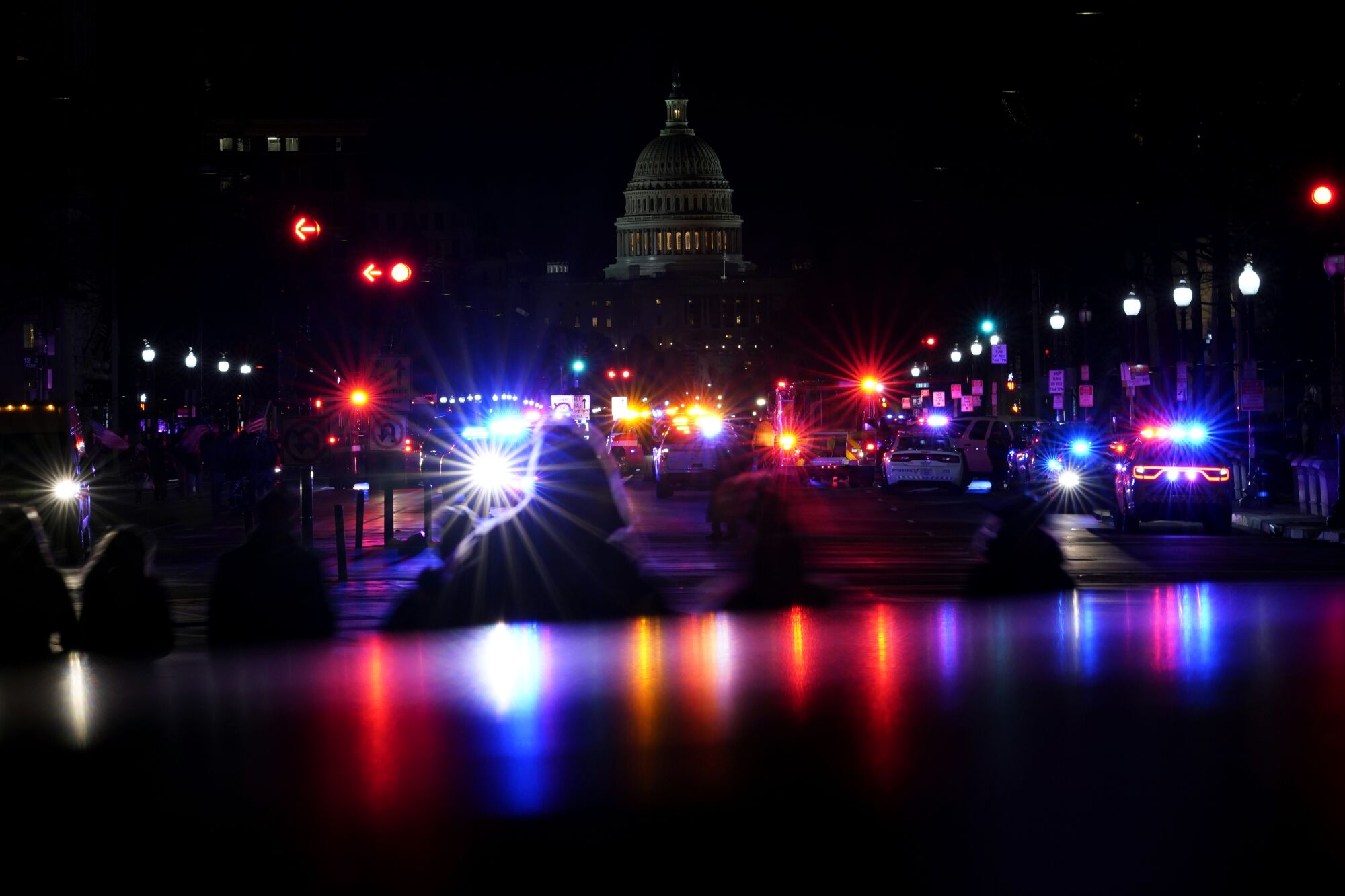 Red and blue police lights in front of the Capitol Dome