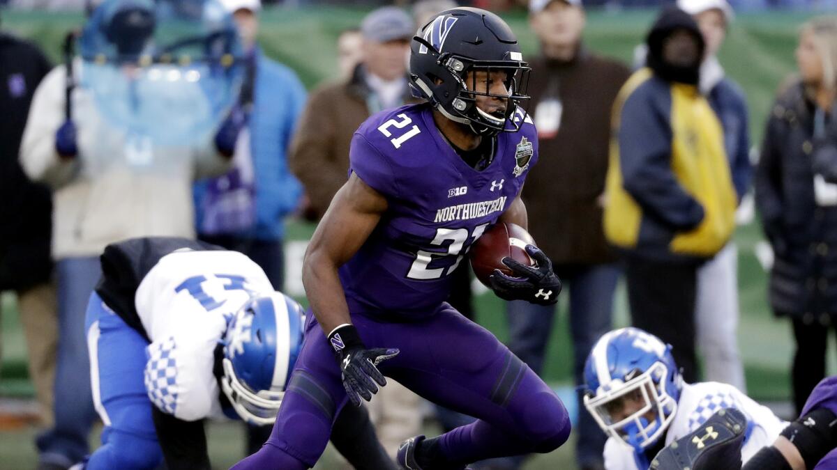 Northwestern running back Justin Jackson finds room to run against Kentucky during the first half of the Music City Bowl on Friday.
