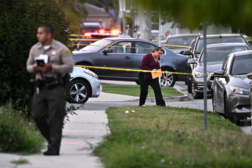 Los Angeles, California April 10 2022-Law enforcement investigators comb the scene of a shooting along Blakley Ave. in Willowbrook Saturday where two people were shot dead and four injured. (Wally Skalij/Los Angeles Times)