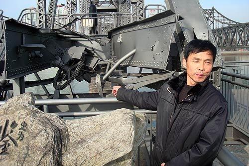 A Chinese tourist points to wreckage on the so-called Broken Bridge in Dandong, China, which is across the Yalu River from North Korea. The original bridge was nearly destroyed in U.S. bombing raids during the Korean War. The Chinese side was rebuilt and turned into a living history museum.