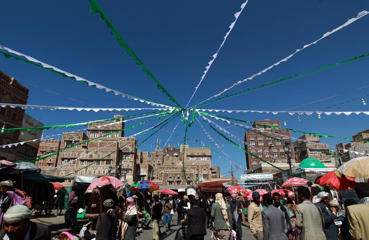 People walk under decorations erected ahead of the celebrations of the birth of Prophet Mohammed in the Yemeni capital, Sana, on Dec. 31.