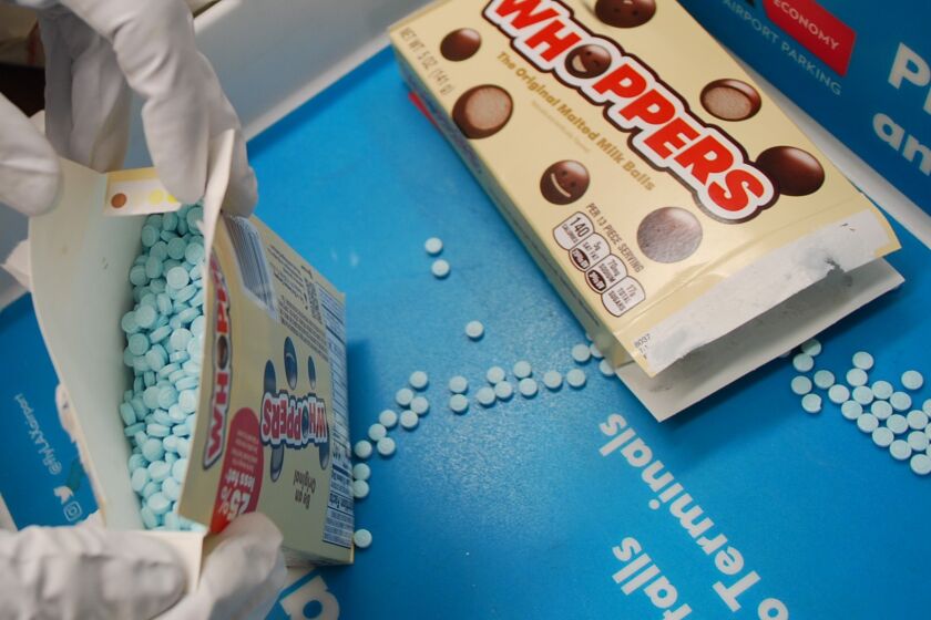 A box of Whoppers with round blue pill instead of candy. Sheriffs department confiscated fentanyl pills packaged in candy wrappers as a suspect attempted to go through TSA screening.