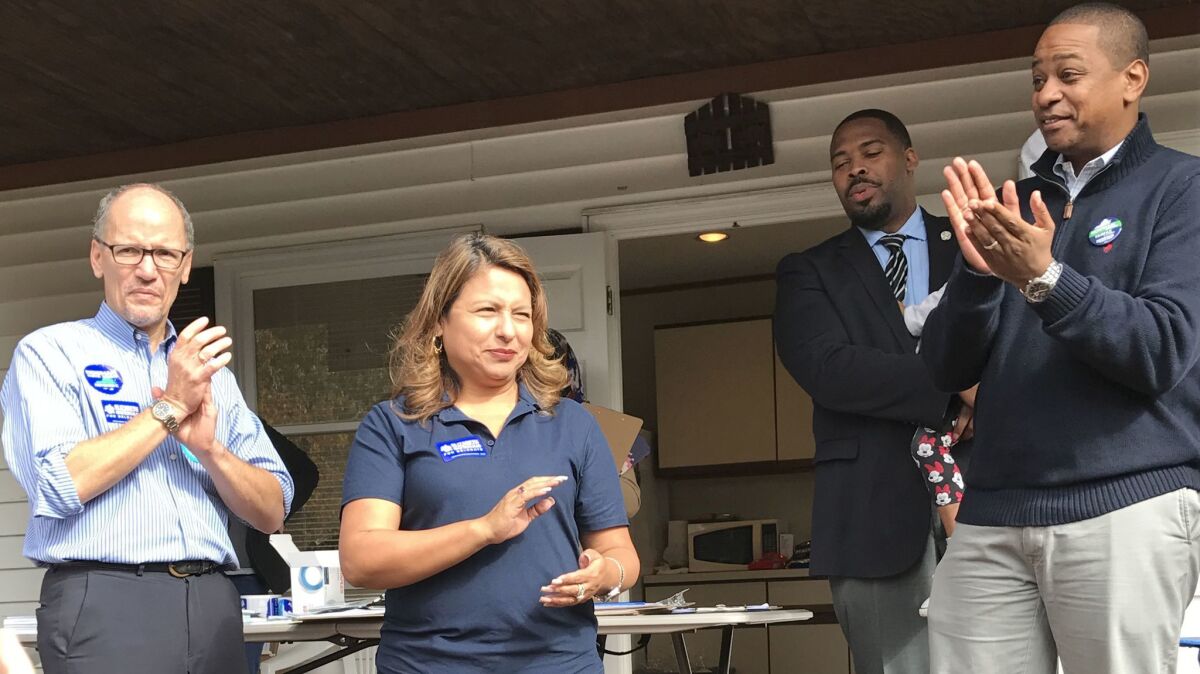 At a volunteer gathering in Woodbridge, Va., House of Delegates candidate Elizabeth Guzman applauds the audience. With her are DNC Chair Tom Perez, left, former Delegate Michael Futrell and Justin Fairfax, right, the Democratic candidate for lieutenant governor.