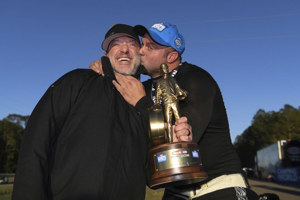 In this photo provided by the NHRA, Matt Hagan, right, kisses team owner Tony Stewart after winning the Amalie Motor Oil NHRA Gatornationals Funny Car auto race at Gainesville Raceway, in Gainesville, Fla., Sunday, March 13, 2022. Hagan defeated Blake Alexander in the final round to give Tony Stewart Racing its first NHRA Camping World Drag Racing Series victory. (Jerry Foss/NHRA via AP)