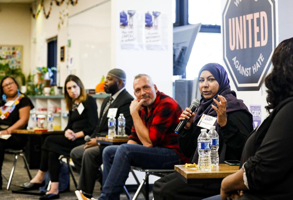 a group of panelists sit in a library