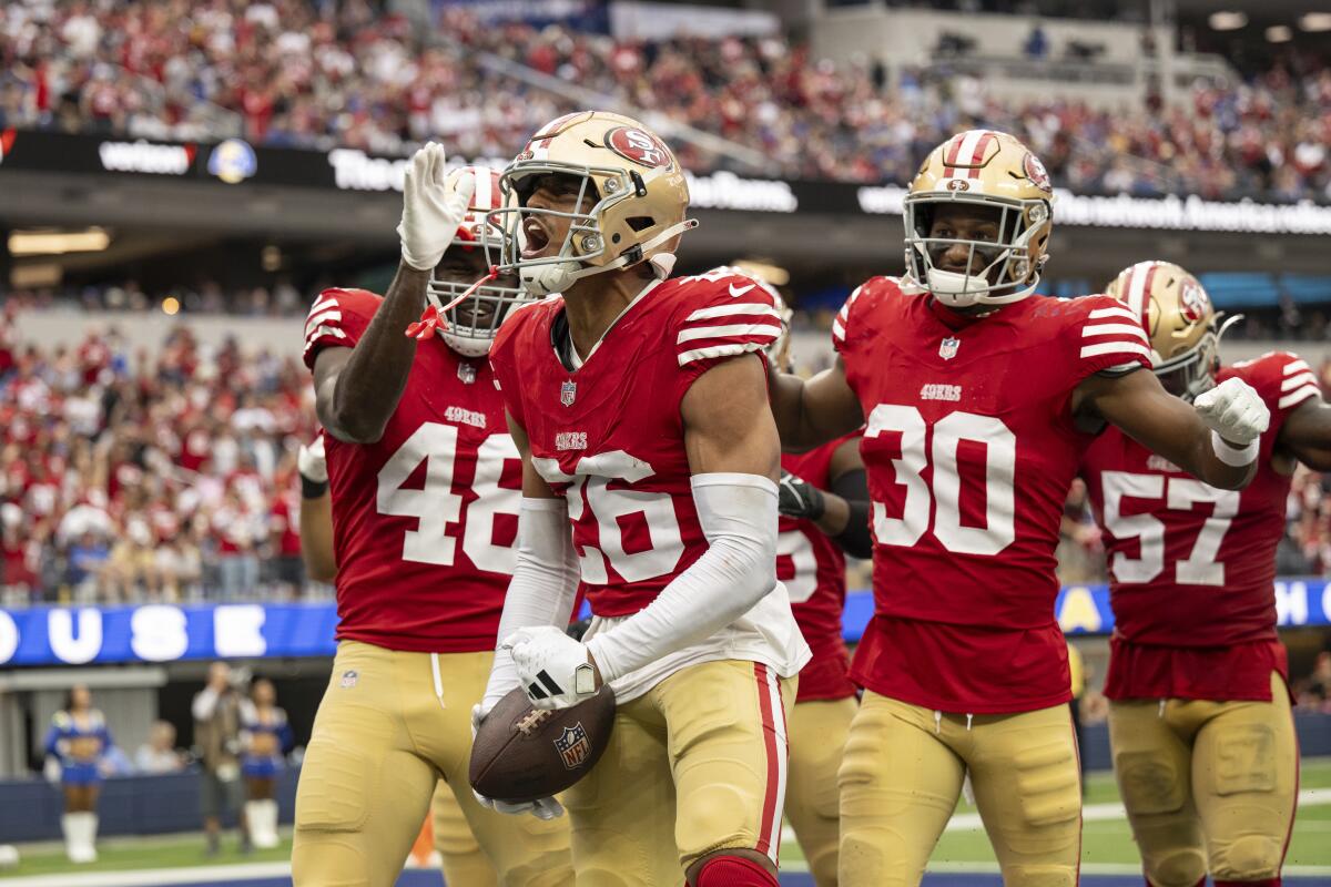 San Francisco 49ers cornerback Isaiah Oliver reacts on his interception with linebacker Oren Burks and safety George Odum.