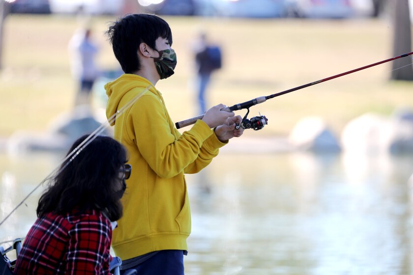 A boy with a mask on fishes at Mile Square Park on Jan. 30. 
