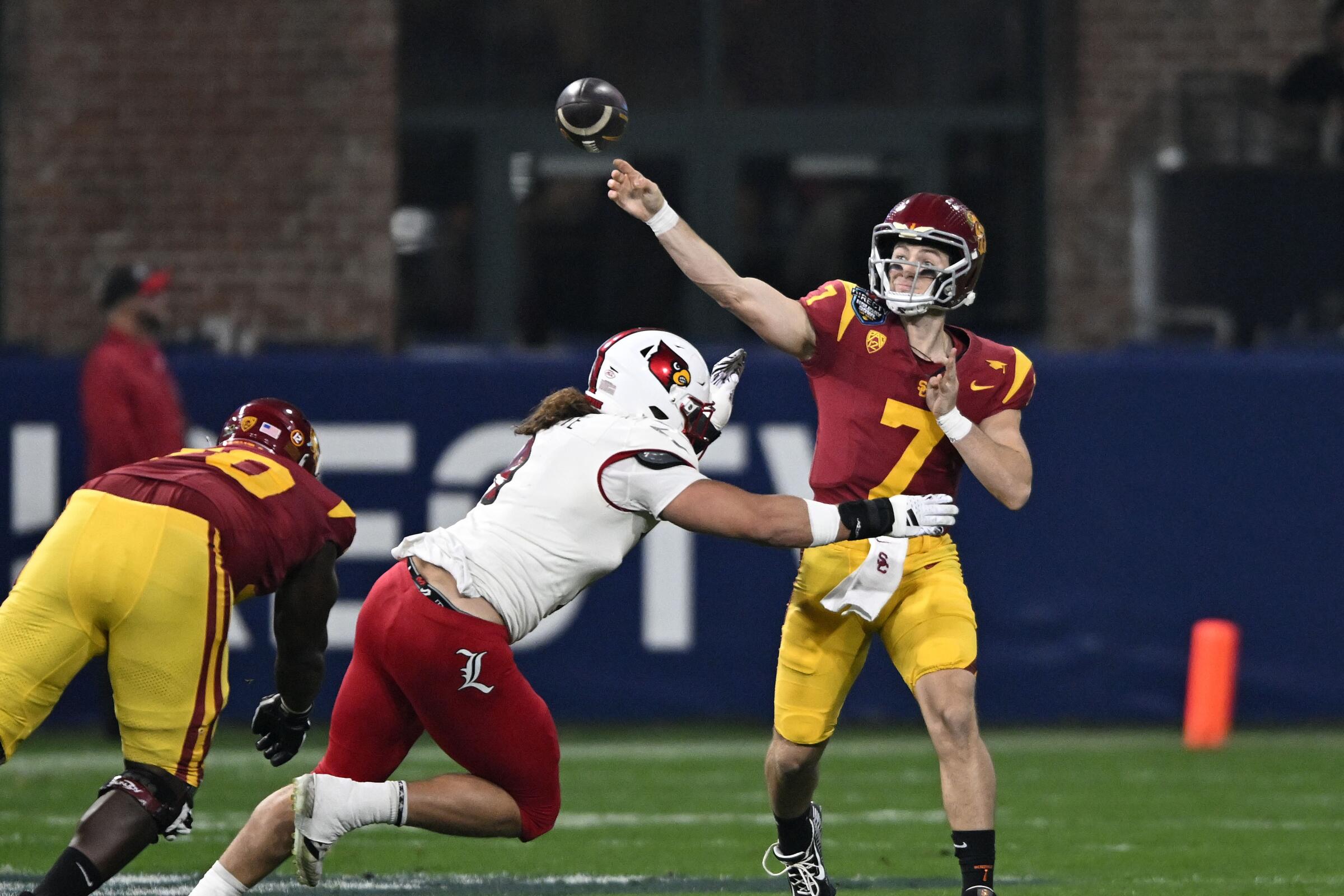 USC quarterback Miller Moss throws a pass under pressure from Louisville defensive lineman Ashton Gillotte
