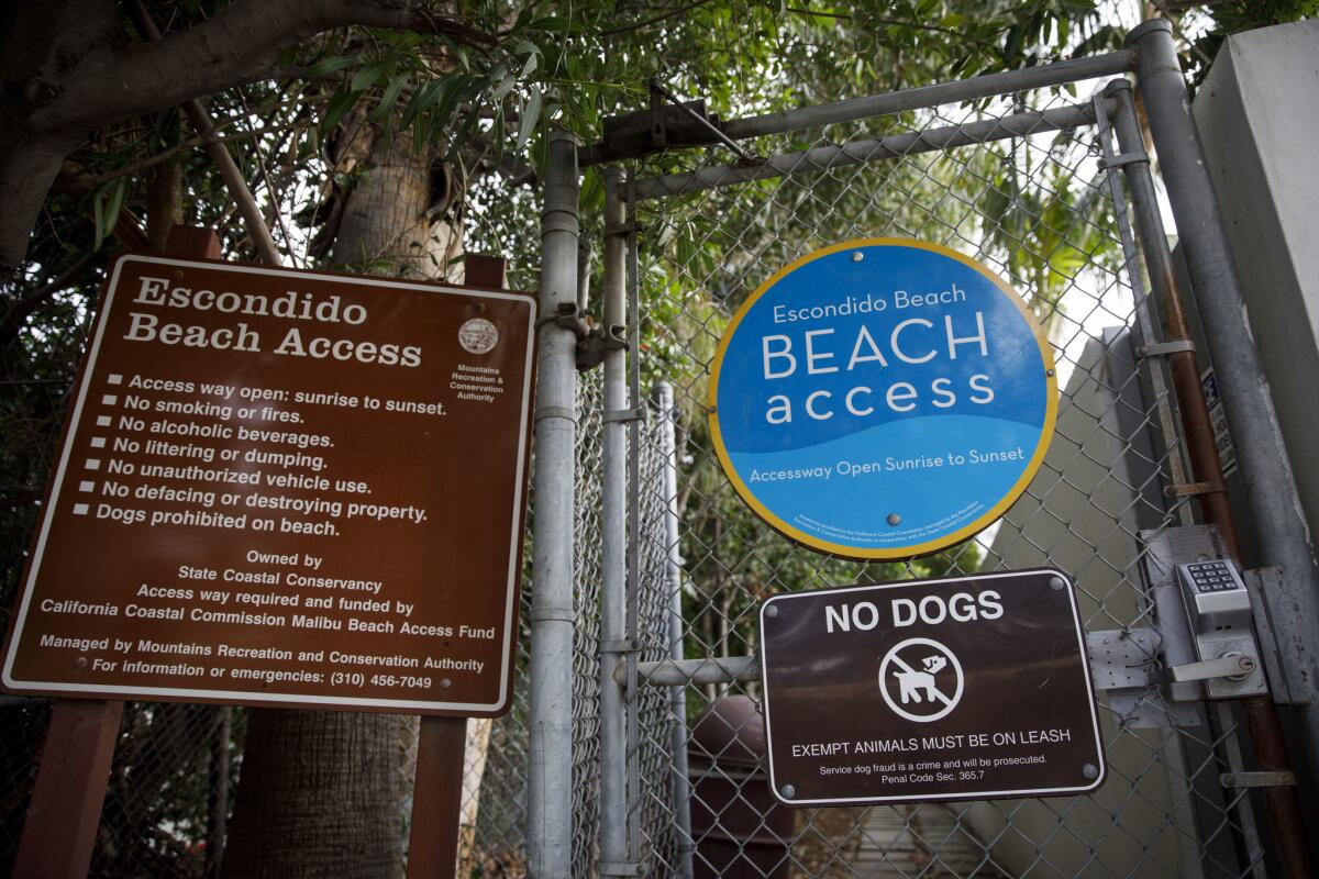 Signage on a gate for public access to Escondido Beach, accessible via a coastal access pathway in Malibu.