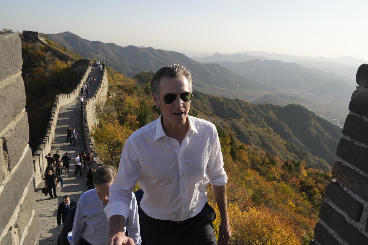 California Gov. Gavin Newsom walks up a section of the Great Wall.