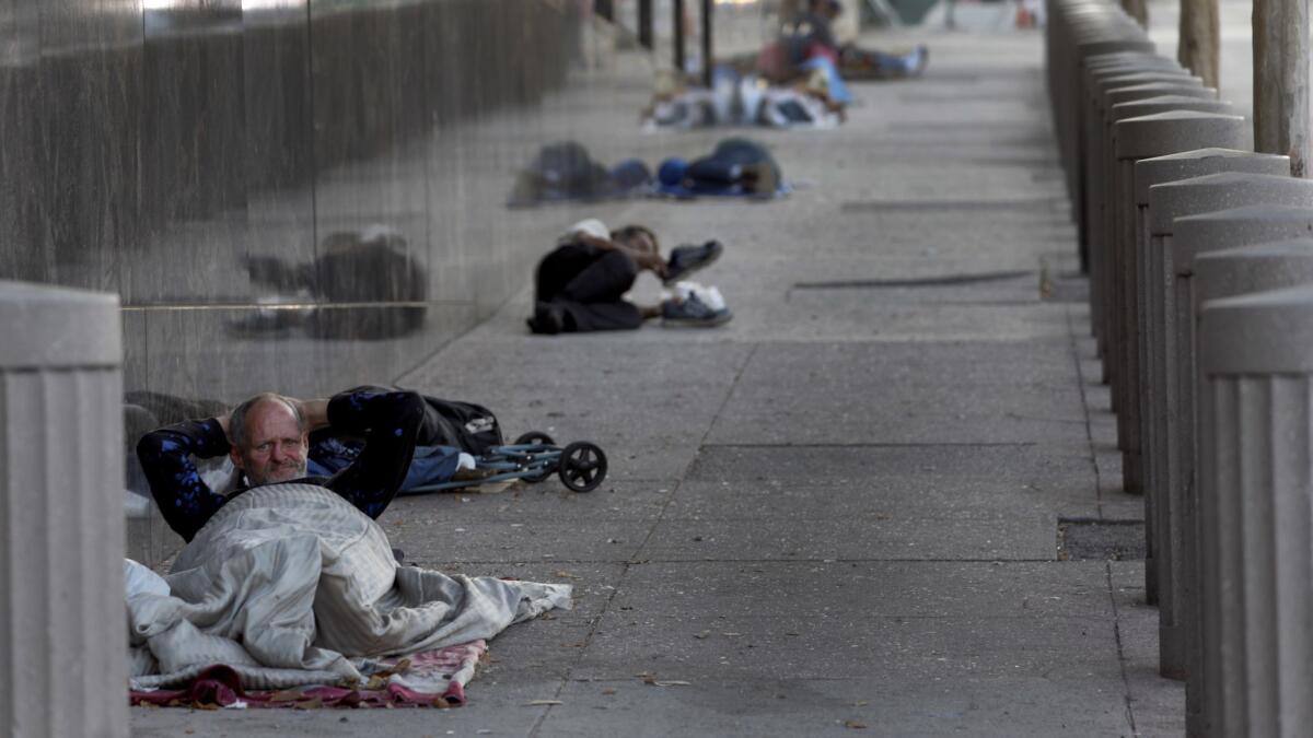 Lewis Payne, 55, beds down for the night on the sidewalk on Aliso Street, not far from the emergency homeless shelter at El Pueblo near the corner of Arcadia and Alameda streets in downtown L.A.