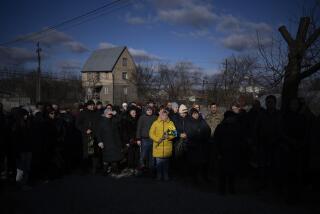 FILE - People pay respect as the coffin containing the body of Serhii Havryliuk, 48, passes by during his funeral procession in Tarasivka village, near Kyiv, Ukraine, Wednesday, Feb. 15, 2023. Serhii Havryliuk, an officer of the Azov Assault Brigade, died while defending the Azovstal steel plant in Mariupol on April 12, 2022 against the Russians. Serhii has finally been buried after DNA tests confirmed his identity. (AP Photo/Emilio Morenatti, File)