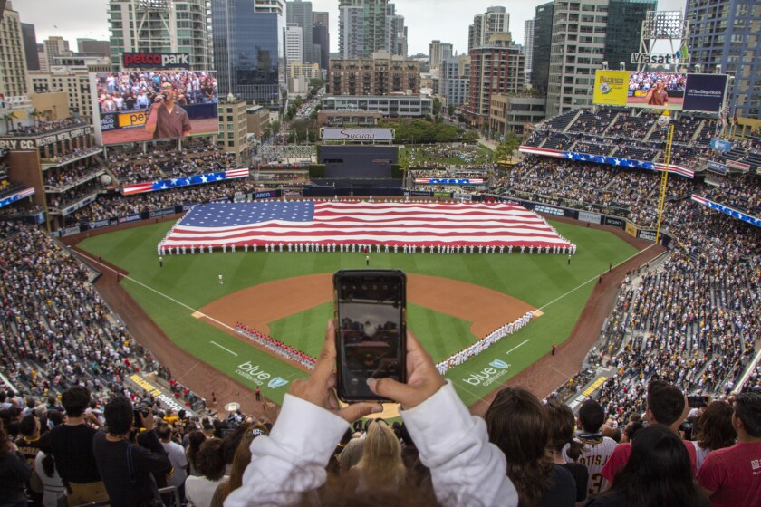 SAN DIEGO, CA - JUNE 17: Navy sailors unfurl the American flag during the national anthem before a baseball game between the San Diego Padres and Cincinnati Reds at Petco Park on Thursday, June 17, 2021 in San Diego, CA.  Thursday marked the first day that coronavirus restrictions were lifted at the stadium, allowing it to be at full capacity.  (Brittany Cruz-Fajron/San Diego Union-Tribune)